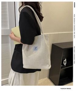 Detail shot of white corduroy tote bag featuring blue fabric label and textured fabric