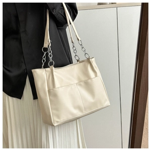 Detail of minimalist beige tote bag showing PU leather texture and silver chain strap