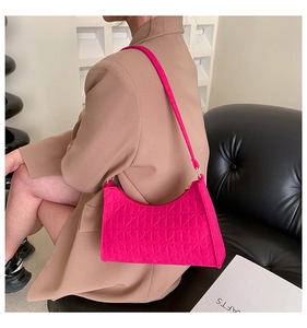Detail of rose pink underarm bag with 3D embossed heart texture and gold hardware