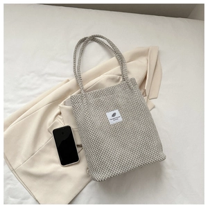 Flat lay of a beige corduroy tote bag with a fashion patch on a white stylish background
