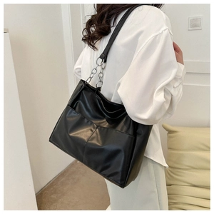 Close-up of black PU leather tote bag featuring front utility pockets and chain strap