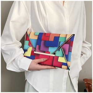 Detail of colorful geometric block pattern and gold metal buckle on envelope clutch bag