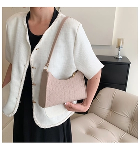 Close-up of minimalist beige felt shoulder bag with geometric floral embossed texture