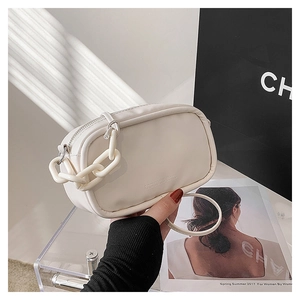 Detail of off-white faux leather square bag featuring chunky chain and embossed text
