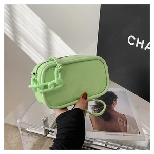Detail of neon green leather mini handbag with bold chunky chain and fashion engraving
