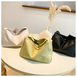 Detailed view of three soft faux leather shoulder bags in beige, yellow, and black colors