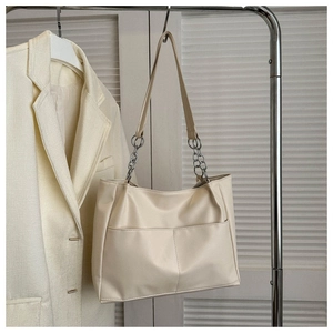 Detail of off-white PU tote bag showing stitching and silver chain shoulder strap