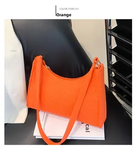 Detailed view of an orange felt shoulder bag with embossed geometric patterns