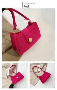 Detail of fuchsia crocodile texture underarm bag with decorative wooden button