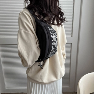 Minimalistische schwarze Mond-Brusttasche mit weißem Buchstabendruck auf einem Model