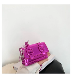 Detail of metallic pink mini bag featuring dual buckles and clear acrylic chain strap