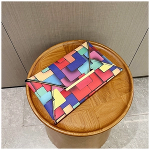 Detail of colorful geometric pattern envelope clutch bag with gold metal trim