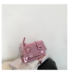 Detail of metallic pink mini satchel bag with double buckles and clear chain strap