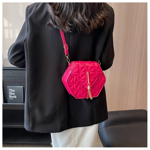 Chic magenta hexagonal crossbody bag with geometric quilting and gold tassel detailing
