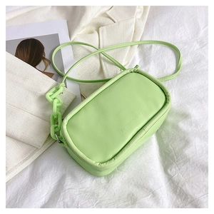 Detail view of mint green crossbody bag with textured PU leather and chain strap
