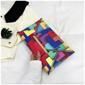 Detail of colorful geometric patchwork envelope clutch with elegant gold metal trim