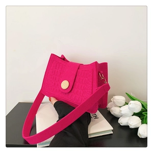 Detailed view of magenta faux-crocodile skin shoulder bag with elegant wooden buckle
