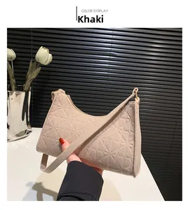 Detail of khaki felt underarm bag featuring heart-shaped embossed pattern and gold hardware