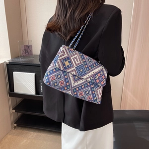 Ethnic knit shoulder bag with colorful geometric patterns and blue chain strap