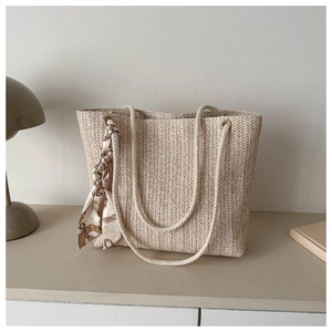 Détail du sac cabas en paille tressée avec poignées en corde et foulard en soie