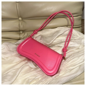 Detail of pink leather baguette bag with knotted straps and embossed brand logo