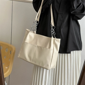 Minimalist beige PU leather tote bag with silver chain strap shown on a model