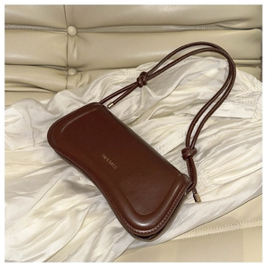 Detailed view of the dark brown leather bag with golden logo and knotted strap detail