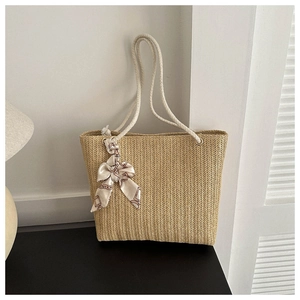Détail d'un sac cabas en paille tissé main avec anses en corde et foulard en soie
