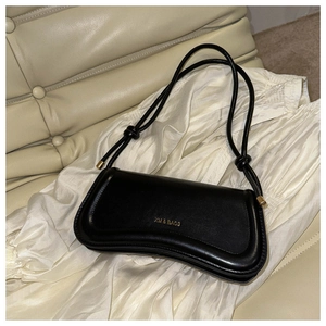 Detail of black leather baguette bag featuring gold XM & BAGS logo and sleek metal hardware