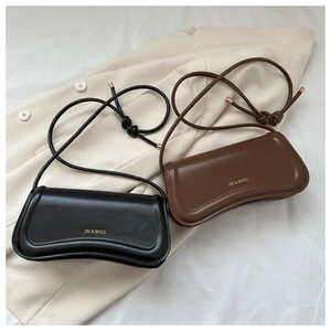 Detail of minimalist black and coffee brown leather shoulder bags with gold logo text