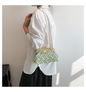 Detail of light green woven texture shell bag with gold chain strap on model