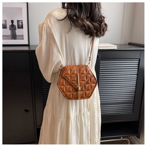 Brown faux leather crossbody bag with quilted hexagon pattern and gold fringe detail