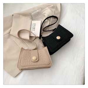 Close-up of minimalist crocodile embossed felt shoulder bags with vintage wood button details