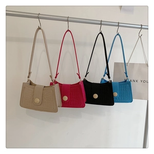 Detail of colorful baguette bags with crocodile texture and metal buckle on hangers