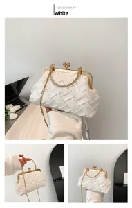 Detail of white woven evening bag with gold sphere clasp and metallic handle texture