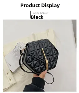 Detail of black quilted shoulder bag with golden tassel and metal bar closure