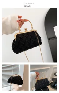 Close-up of black woven shell bag featuring vintage gold frame and pearl clasp detail