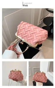 Detail of pink woven clutch bag with gold metal frame and decorative handle