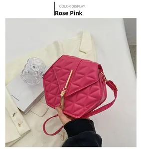 Detailed close-up of a rose pink quilted hexagonal handbag with gold tassel hardware