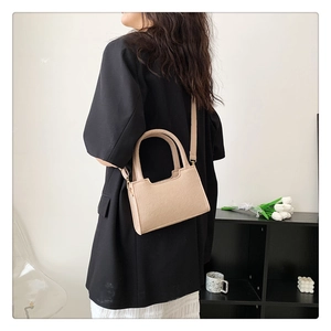 Chic beige felt square crossbody bag worn by a model in a minimalist blazer