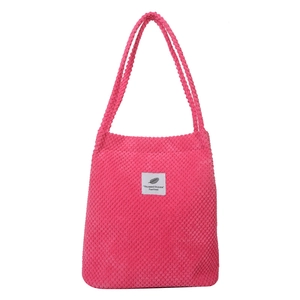 Minimalist rose red corduroy tote bag with square fabric label and dual carry handles