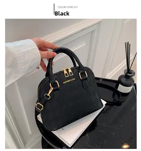 Close-up of black diamond-quilted shell bag with gold hardware and brand logo detail