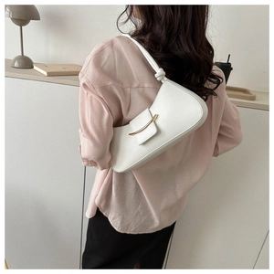 Close-up of white leather hobo bag featuring gold buckle and knot handle detail
