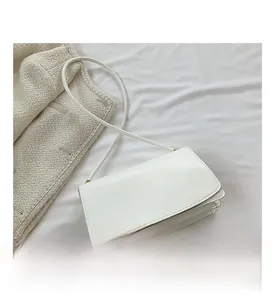 Detailed top view of white PU leather rectangular crossbody bag with slim strap on cloth
