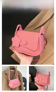 Detailed views of a pink saddle bag with adjustable strap and floral leather charm