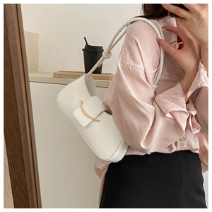 Detailed view of white faux leather underarm bag featuring gold buckle and knotted strap