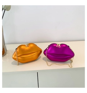 Détail de sacs bandoulière en forme de lèvres, orange et violet métallisé, chaînes dorées