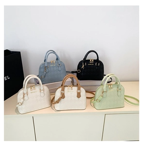 Multi-colored quilted shell handbags displayed on white steps with dual handles