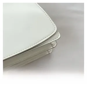 Detailed side view of white faux leather bag showing stitching and multi-layered structure