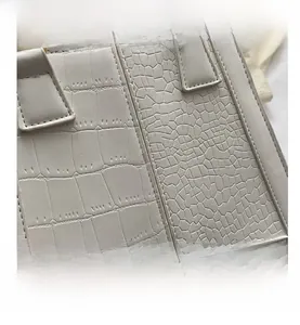 Detail shot of white handbag showing crocodile and snake skin texture patterns